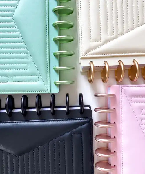 Collection of colorful planners with different cover materials and colors.