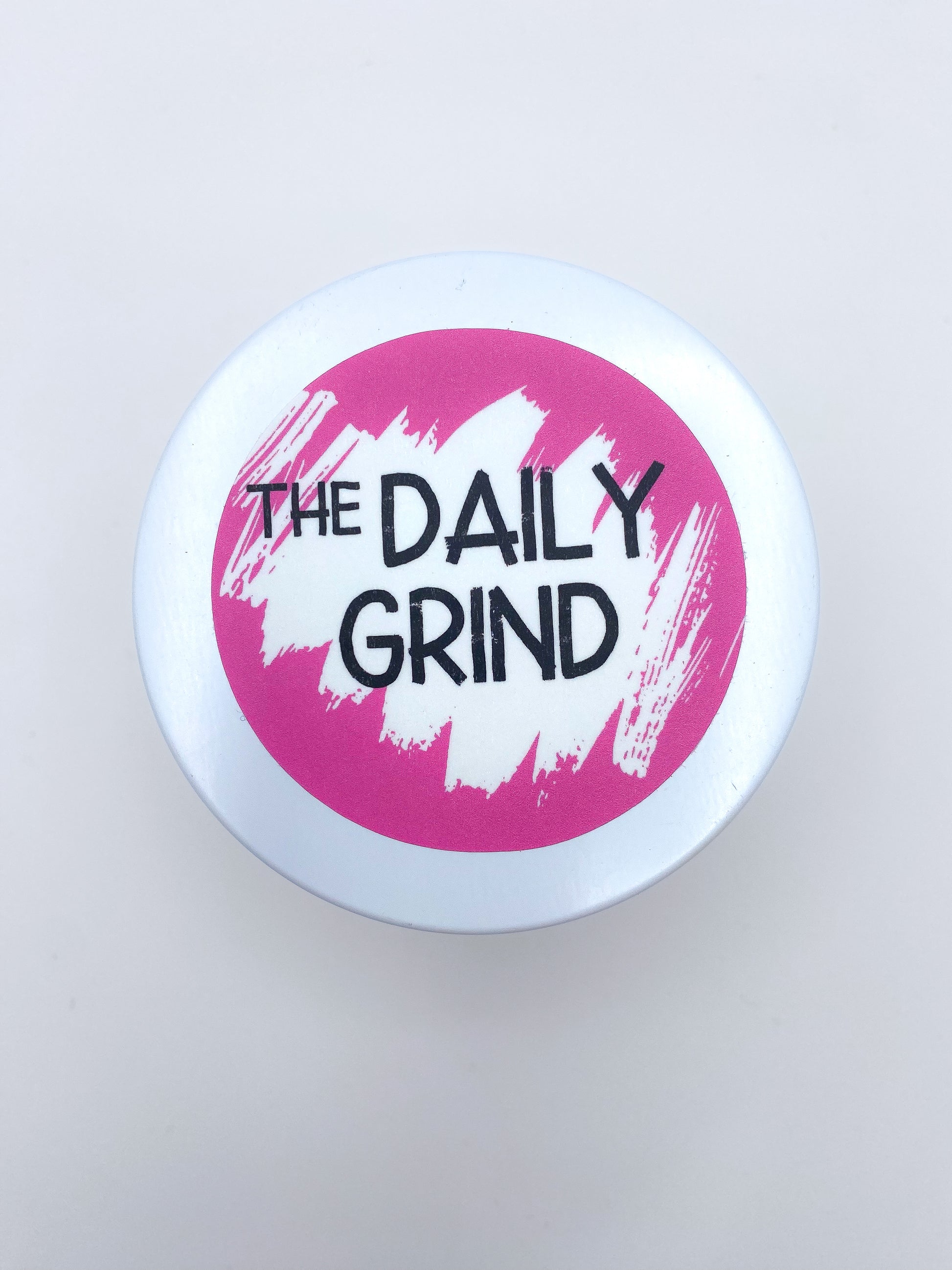 "The Daily Grind" white candle lid with pink label