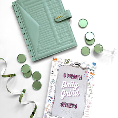 Green planner cover and discs with &quot;4 Month Daily Grind Sheets&quot; insert