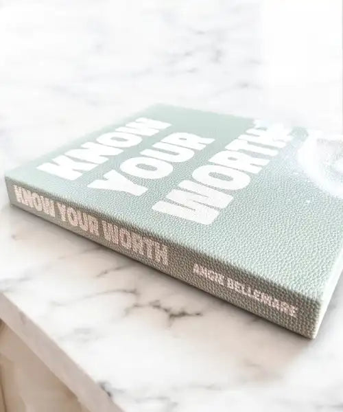 Book titled 'Know Your Worth' by Angie Bellemare on a marble surface
